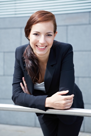 Happy young business woman smiling on a railingの写真素材