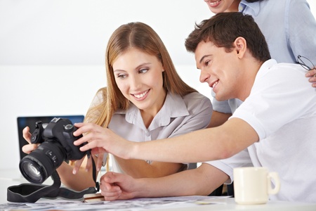 Participants of a photo workshop looking at camera displayの写真素材