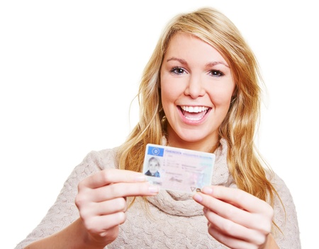 Happy young woman showing proudly her new driving licenceの写真素材
