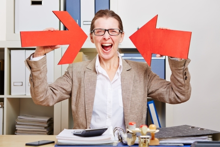 Cheering elderly business woman pointing with two red arrows to herselfの写真素材