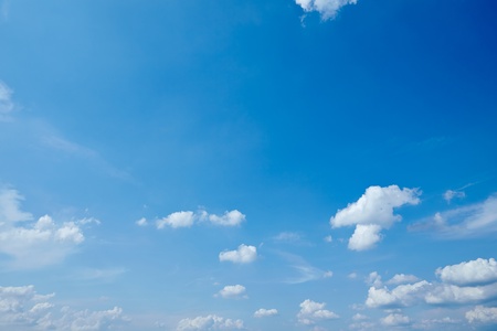 Bright blue sky with some little fluffy white cloudsの写真素材