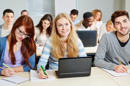 Students studying with laptop computer in class in universityの写真素材