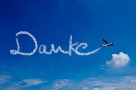 Airplane painting the German word Danke (Thanks) in the skyの写真素材