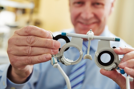 Optician with trial frame to determine prescription values of glasses