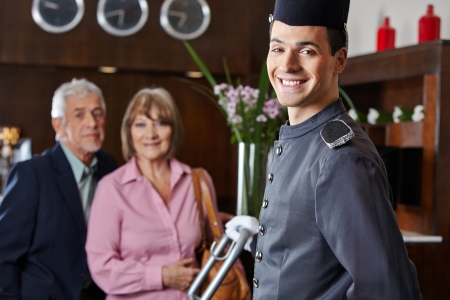 Smiling concierge with senior couple in a hotelの写真素材
