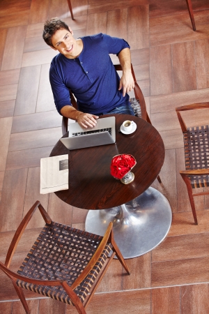 Young business man in cafÃ© working at laptop and drinking coffeeの写真素材