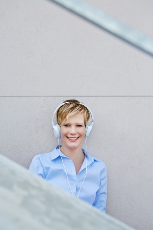 Happy young woman with headphones listening to musicの写真素材