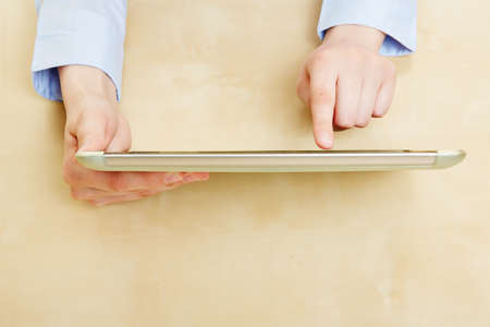 Hands of woman with tablet PC on a desk