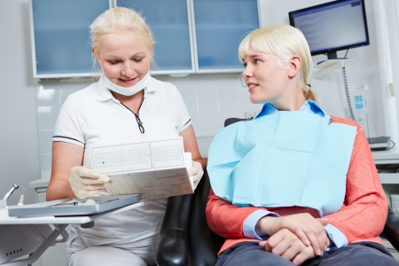 Dentist reading medical record of patient prior to dental treatmentの写真素材