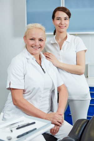 Portrait of a happy female dentist with a dental assistantの写真素材