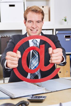 Happy business man holding a red internet sign in the officeの写真素材