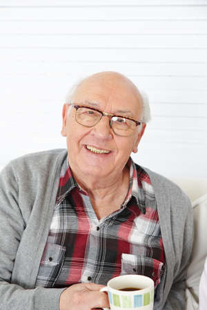 Happy senior man drinking a cup of coffee in the morning