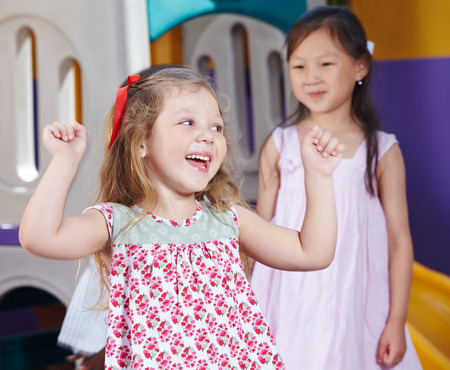 Cheering girl in a kindergarten group clenching her fistsの写真素材