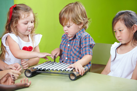 Boy playing xylophone in kindergarten at musical educationの写真素材