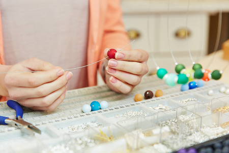 Juweler at work in a jewelry store creating a pearl necklace