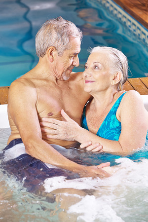 Happy senior couple relaxing in a spa hotel whirlpoolの写真素材