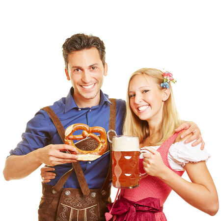 Happy couple celebrating Oktoberfest with beer and pretzelの写真素材