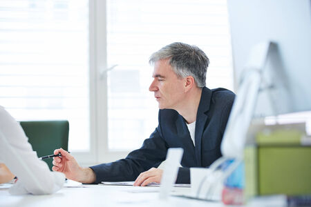 Elderly business man negotiating in meeting in the office