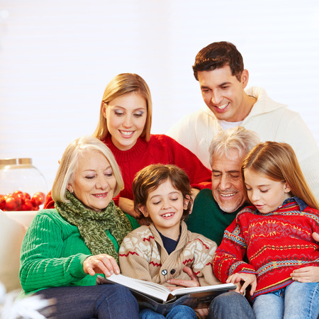 Happy three generation family reading story book at christmas