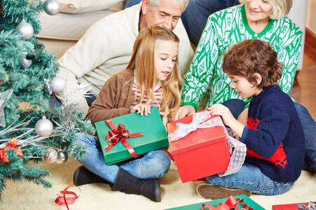 Children celebrating christmas eve with grandparents at home with gifts