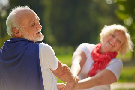 Old senior couple dancing happy together in nature