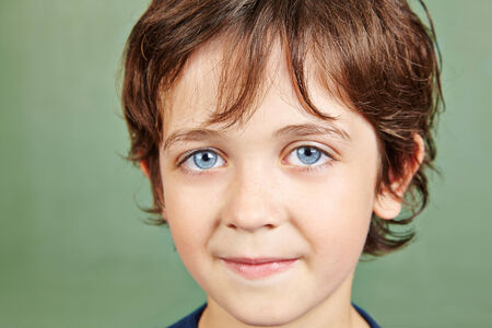 Portrait of a smiling young boy in front of a chalkboard