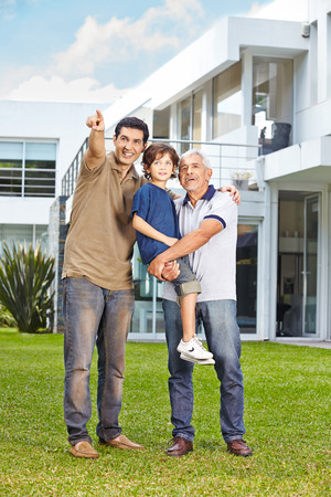 Men of a family looking into the future in garden of a houseの写真素材