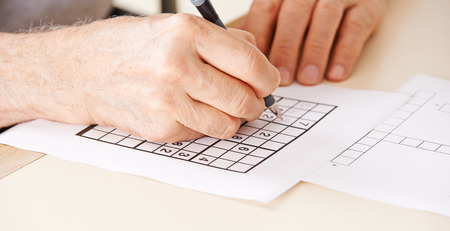 Hand of senior man solving sudoku quiz with a penの写真素材