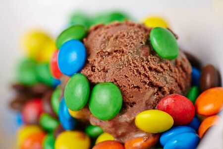 Scoop of homemade chocolate ice cream with colorful chocolate drageesの写真素材
