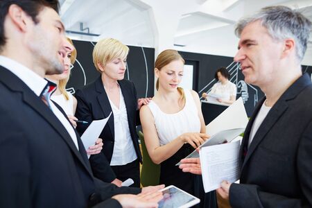 Team of business people in office talking to each other