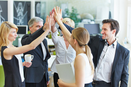 Happy business team making high five with their hands in the office