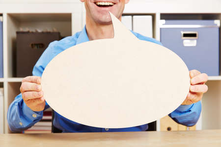 Man talking with big empty speech bubble in his office