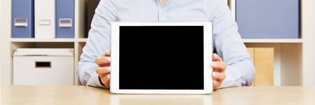 Panorama of hands holding a tablet computer on an office desk