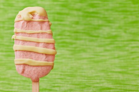 Strawberry ice cream popsicle with stripes of white chocolate
