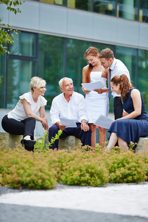 Group of business people having a meeting outdoors in summerの写真素材