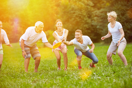 Happy family playing frisbee together in the garden in summerの写真素材