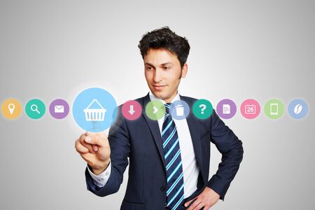 Business man choosing shopping cart icon for online shopping on a touchscreen