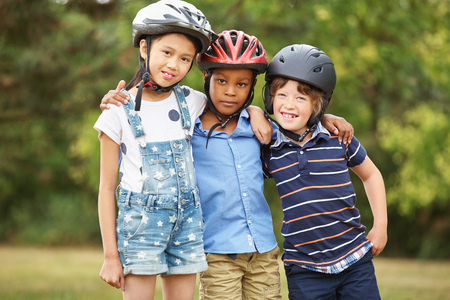 Happy group of children with helmets at the parkの写真素材