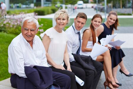 Application candicates waiting for job interview outdoors in front of office
