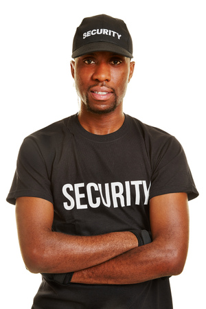 Smiling black man as security guard with his arms crossedの写真素材