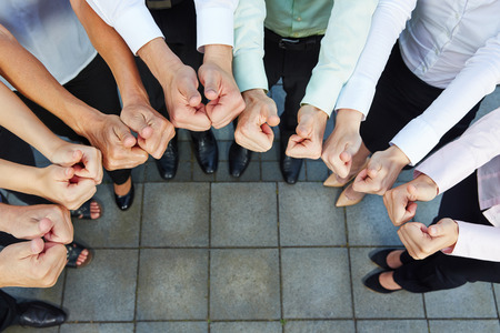 Business team holding many thumbs up in a semicircle from above