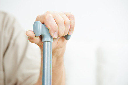 Hand of senior man holding on to a caneの写真素材