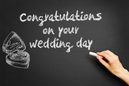 Hand writes "Congratulations on your wedding day" on blackboardの写真素材