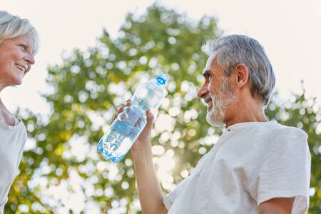 Senior citizens drinking from a water bottle for refreshment in summerの写真素材