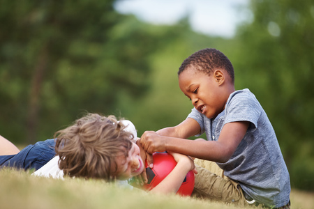 Two kids with soccer ball on the grassの写真素材