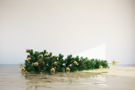 Tipped decorated christmas tree floating in flooded roomの写真素材