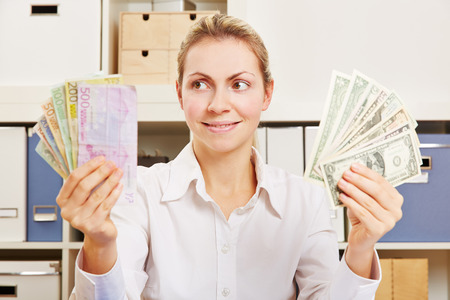 Woman thinking about currency exchange rate between Dollar and Euroの写真素材