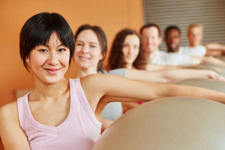 Woman with gym ball in pilates class at fitness studio