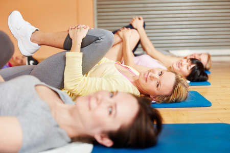 Group of women making gymnastics exercise during pilates classの写真素材