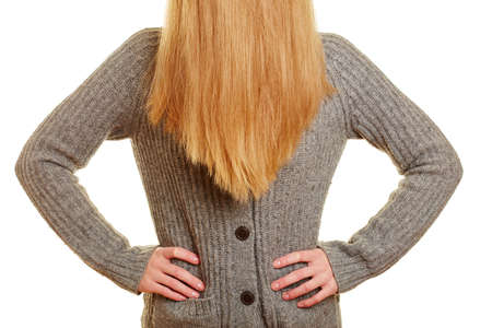 Blond woman with her hands on her waist and her hair on her faceの写真素材